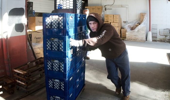 A custodian pushes a large crate