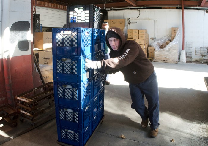 A custodian pushes a large crate